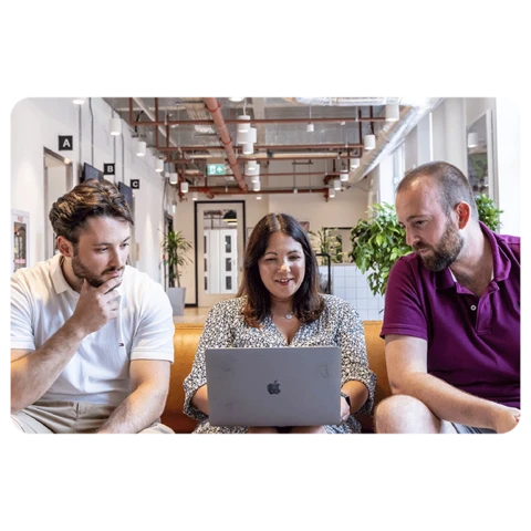 office workers sharing laptop